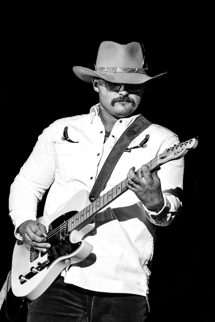 Micah Hughes singing and playing a Telecaster in a white western shirt and cowboy hat